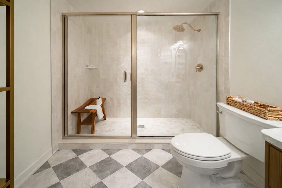 Brightly renovated bathroom featuring a walk-in glass rain shower and stylish finishes for a spa-like experience