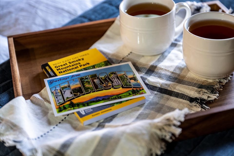 Two warm drinks and local visitor guides are styled as a welcoming introduction to the mountain setting.