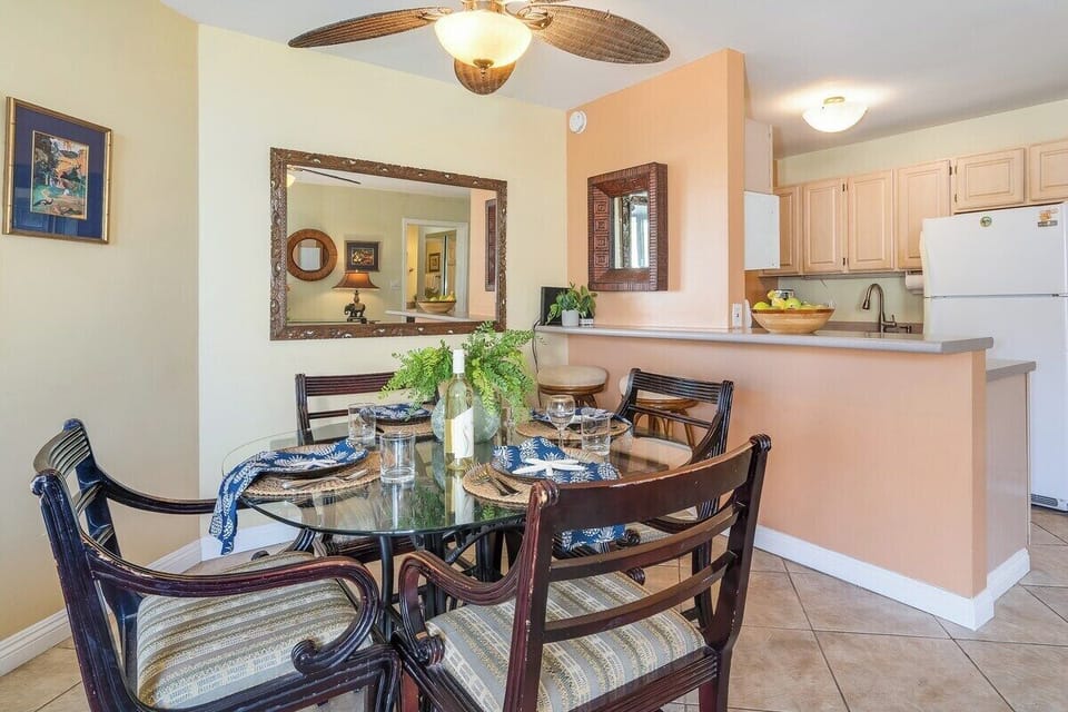 A warm dining nook with wicker seating and tropical accents blending seamlessly with the kitchen area.