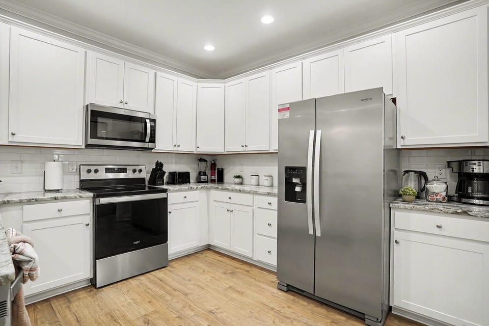 Welcome to Sea Princess: crisp white kitchen with generous island, stainless appliances, and coastal-ready prep space.