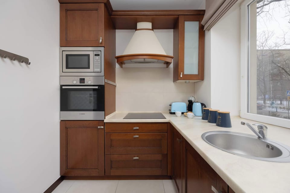 Compact modern kitchen with wooden cabinets and built-in appliances.