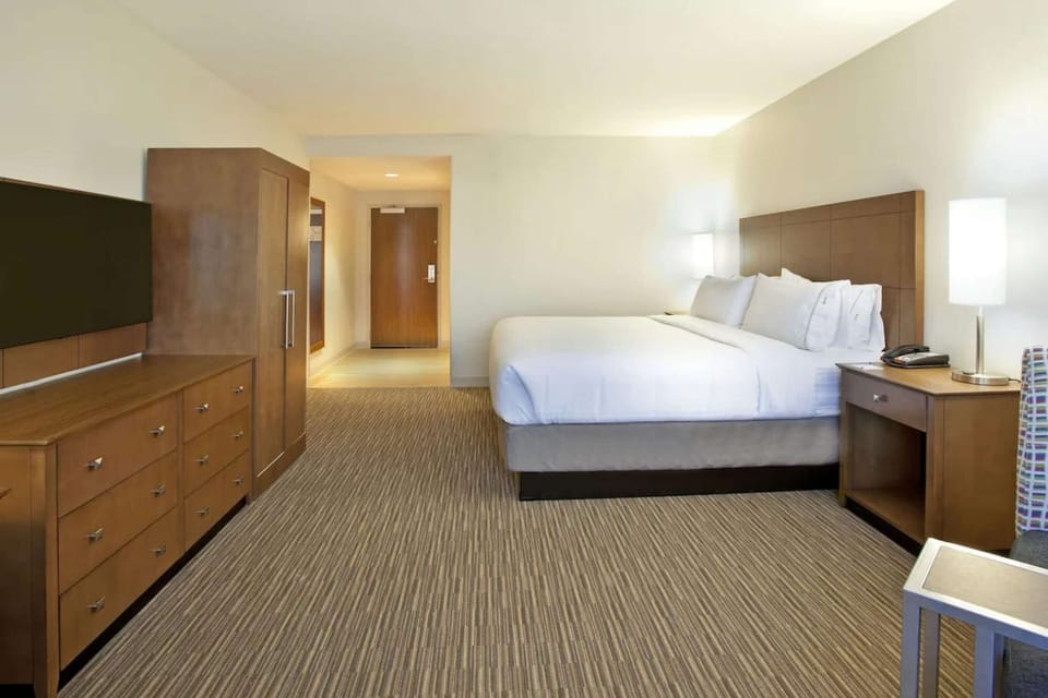 Spacious king room with soft lighting and neutral tones