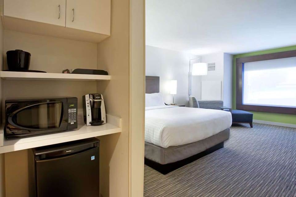 Room view with king bed, microwave, fridge, and coffee maker
