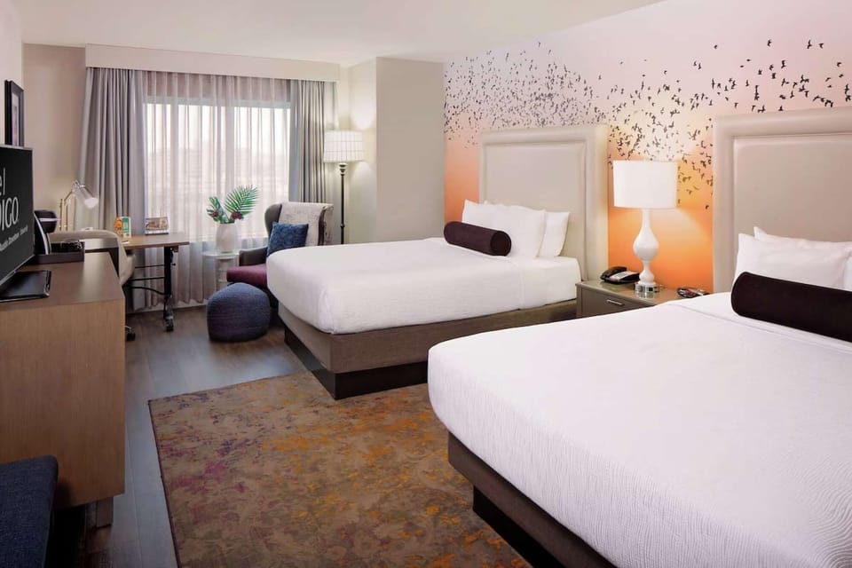 Peaceful queen bed space with lounge chair and floor-to-ceiling light
