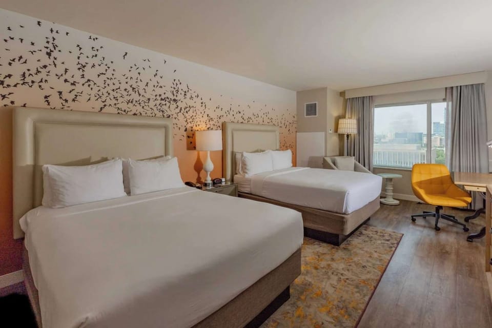 Spacious two-bed room with city views and a comfy desk chair