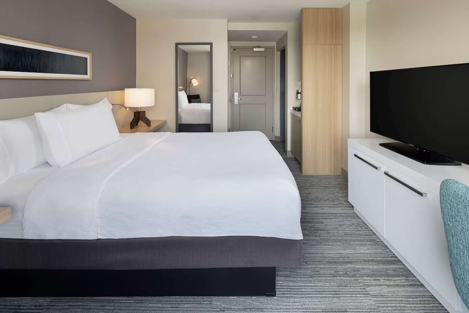 Spacious king room with big bed, flat-screen TV, and work desk