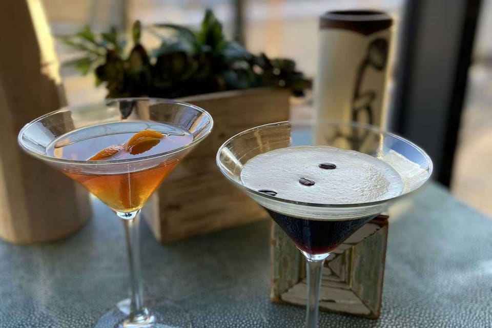 Two craft drinks served in tall glasses on a table