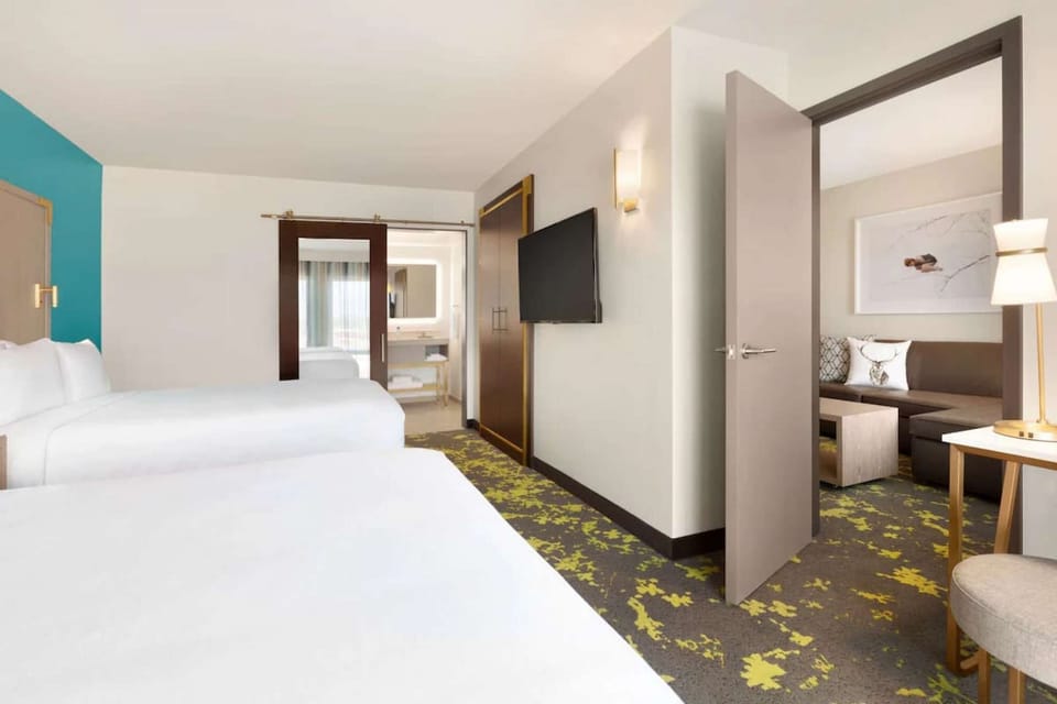Two queen beds with open view into sitting area