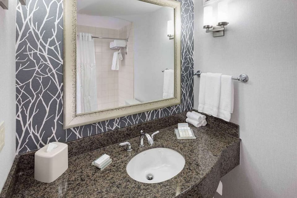Bathroom sink with wide mirror, towels, and counter space