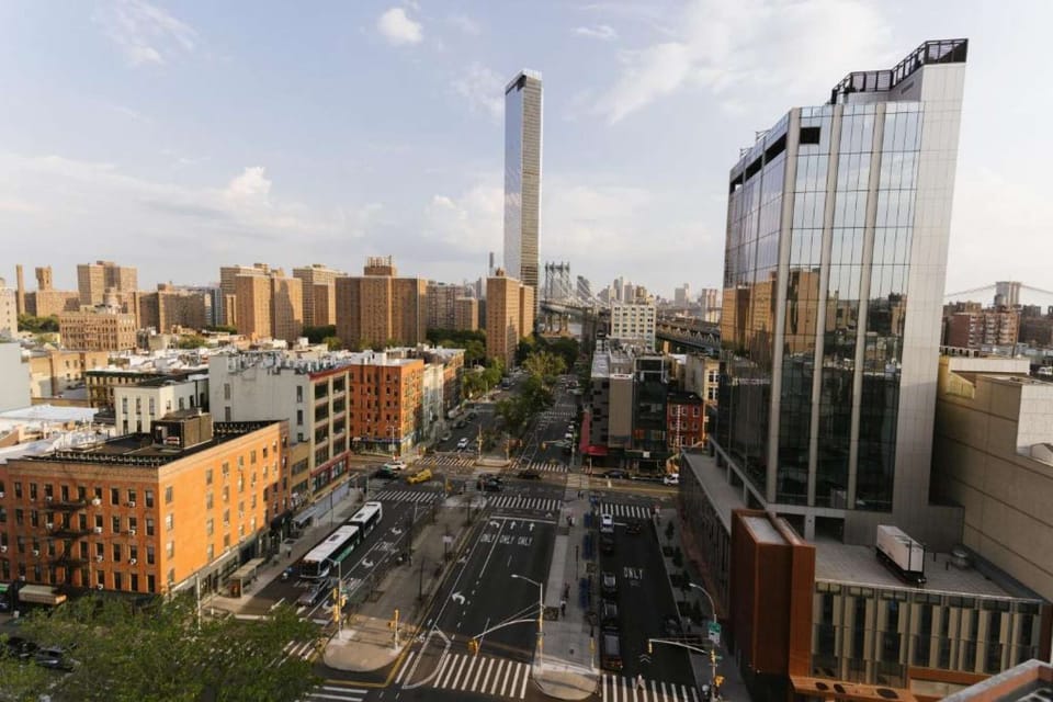 Wide daytime view of city blocks leading toward the tall tower and bridge.