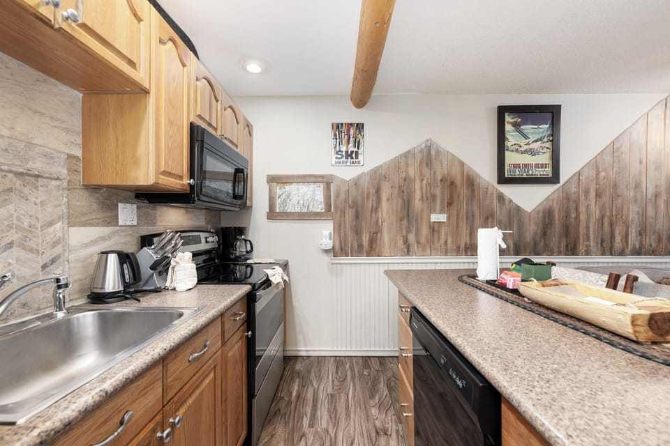 Your fully equipped galley kitchen features warm wood cabinets, granite counters, and everything you need to create memorable meals together.