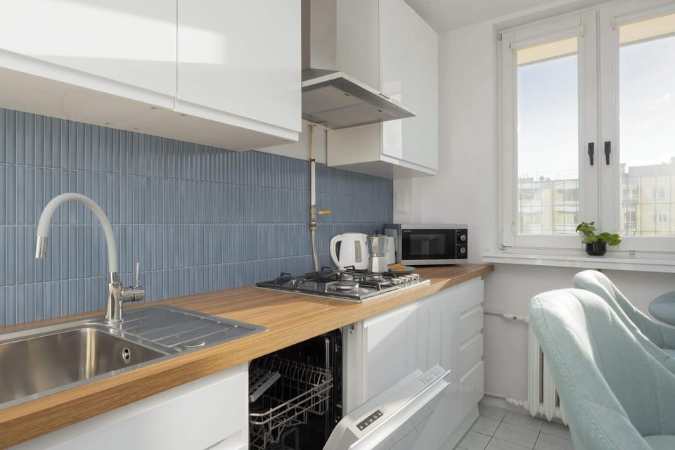 The kitchen's sleek design includes all necessary cookware and utensils. 