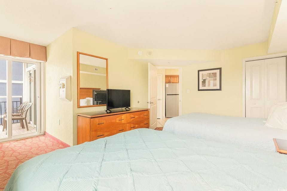 Primary bedroom with multiple amenities and access to the private balcony.
