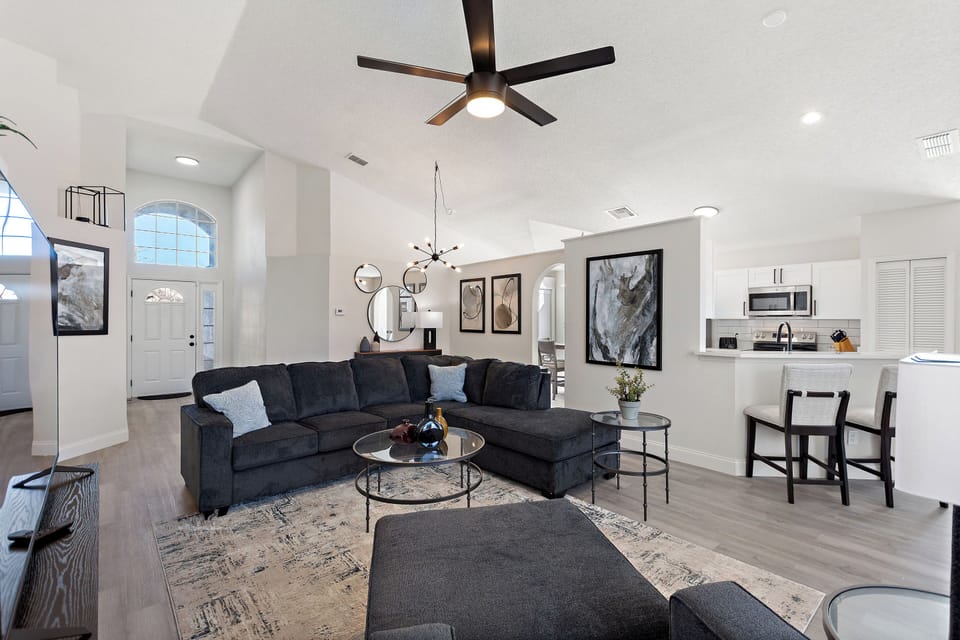 Stylish living room with sectional sofa, armchairs and large flat-screen TV