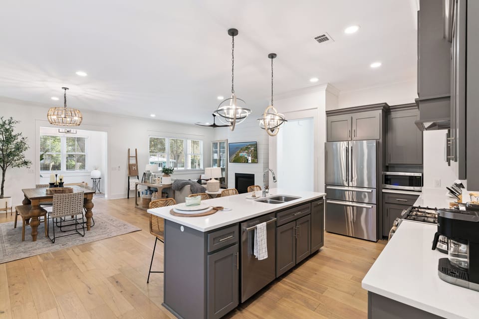 Your gourmet kitchen flows seamlessly into the living space, featuring granite countertops, stainless steel appliances, and stylish pendant lighting perfect for cooking together.