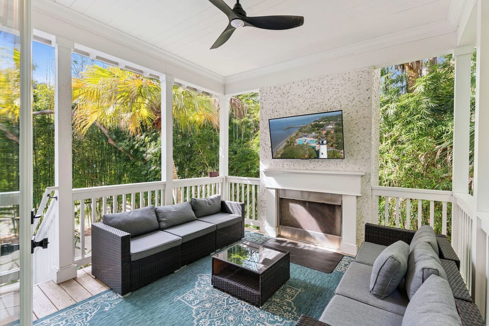 Unwind in your screened porch oasis, where tropical breezes flow through as you relax by the fireplace with garden views.
