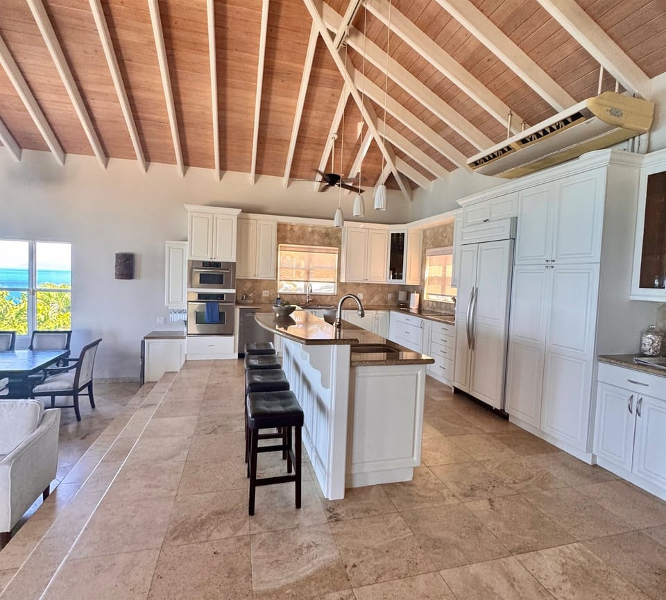 Spacious Kitchen with large island and bar sink, beverage fridge and ice maker. 