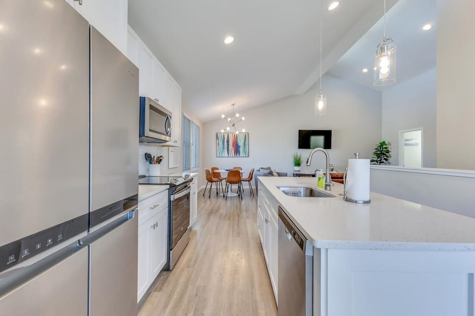 Your fully equipped kitchen flows seamlessly into the dining area, featuring sleek appliances and pristine countertops perfect for preparing memorable meals.