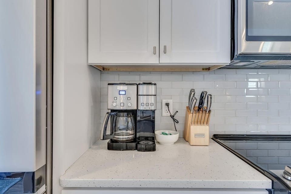 Your modern kitchen comes equipped with premium coffee makers and sharp knives, ready for your culinary adventures.