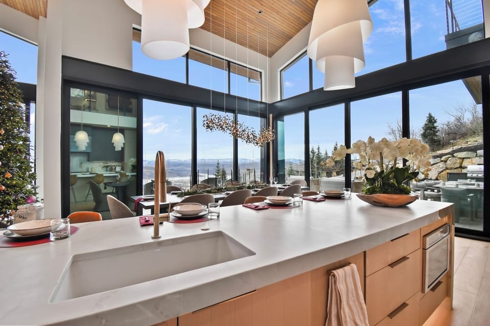 Cook meals while soaking in breathtaking mountain views through these stunning floor-to-ceiling windows that flood your kitchen with natural light.