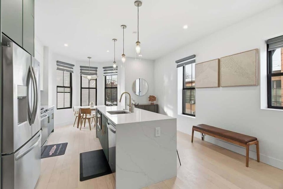 Modern kitchen featuring a breakfast bar with a built in sink and stools, creating a functional and stylish space for meals and everyday us