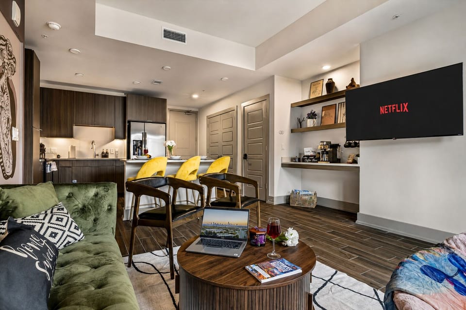 Modern living room with streaming TV, sleek kitchen, and chic breakfast bar