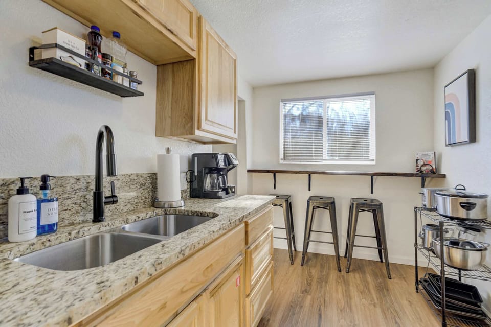 The fully stocked kitchen features warm wood cabinetry and a sleek double stainless steel sink. We provide a complimentary coffee station to help you start your morning off right.