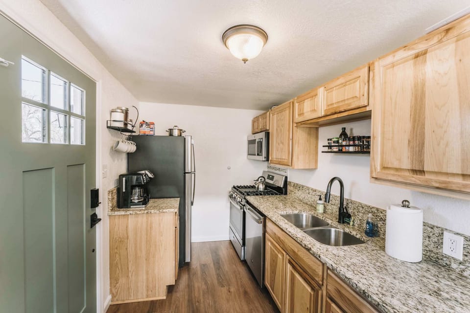 Another angle of the kitchen showcasing the clean layout, functional work surfaces, and thoughtful organization that make cooking and dining easy during your stay.