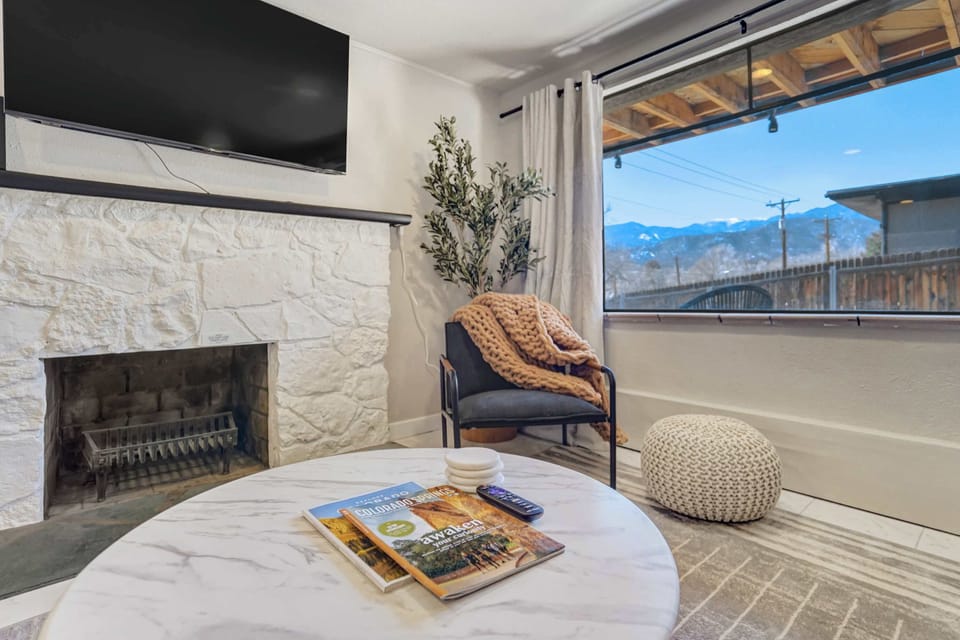 Cozy fireplace framed by a stone surround, paired with comfortable seating for a relaxed place to unwind.