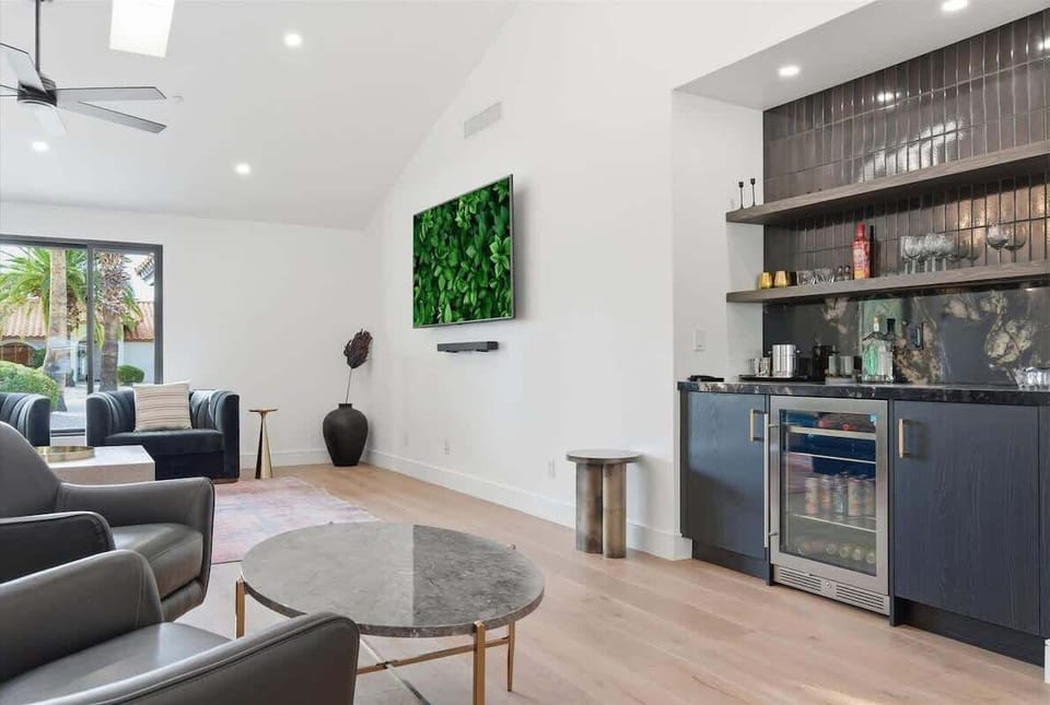 Bright and open living area featuring plush furnishings, a Smart TV, and a wet bar area with a mini fridge.