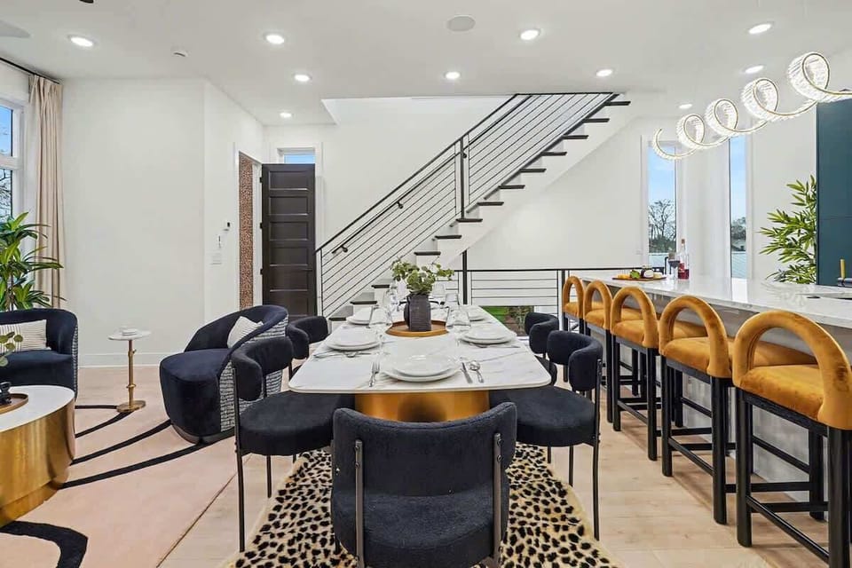 2nd Floor: Dining area featuring a marble and gold table paired with black chairs, offering seating for 6 guests.