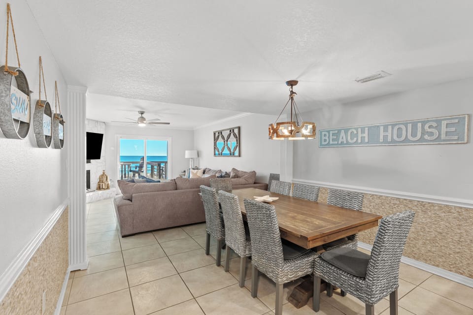 Dining area with a large wooden table and seating for eight, overlooking the living room.