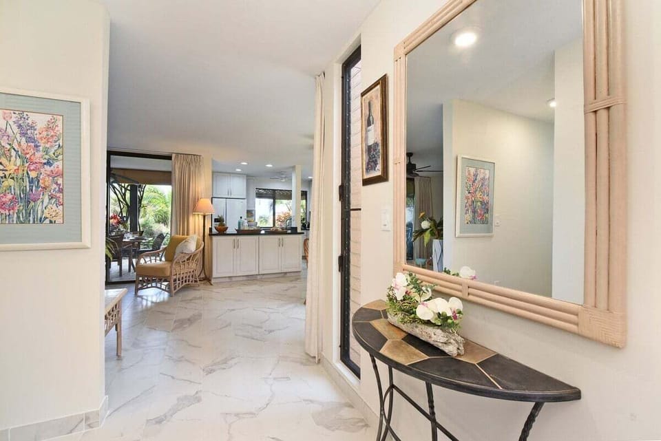 A warm entryway flowing into the living area, highlighted by soft lighting and inviting tropical décor.