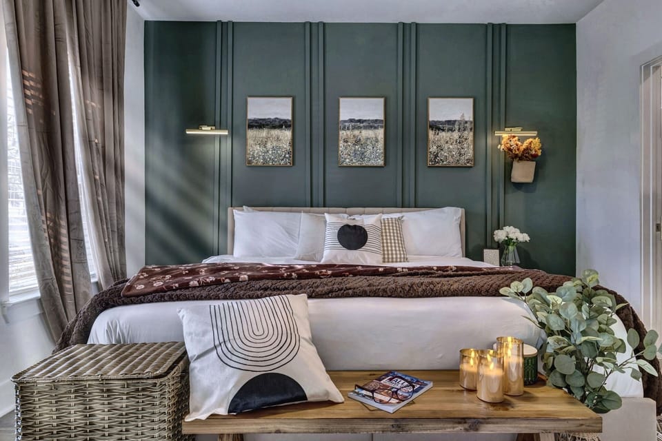Elegant bedroom with cozy king bed and rich green accent wall