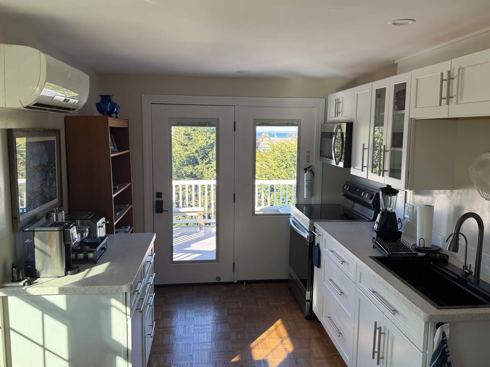 Cook with doors that open to your private deck, surrounded by modern appliances and bright natural light.