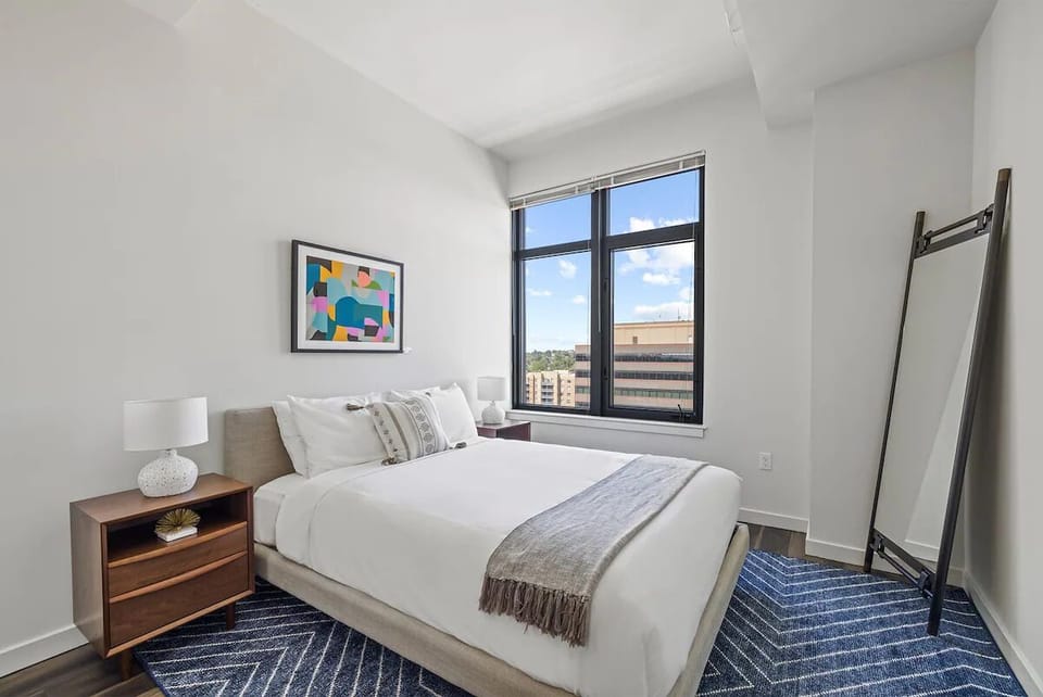 Drift off in crisp linens beside expansive city windows.