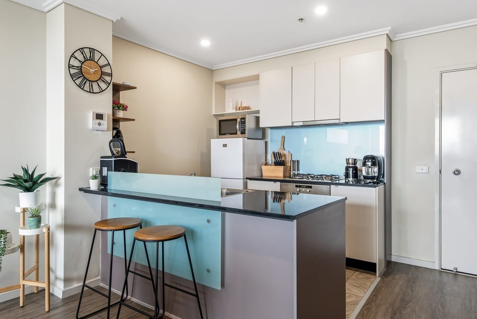 The sleek kitchen island doubles as a convenient breakfast bar, providing the ideal setting for a quick morning coffee, a casual bite, or socializing with the chef while dinner is being prepared.