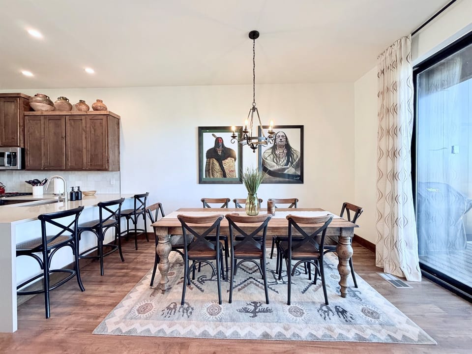 2) Spacious dining table with seating for multiple guests, positioned next to the kitchen for easy serving and entertaining.