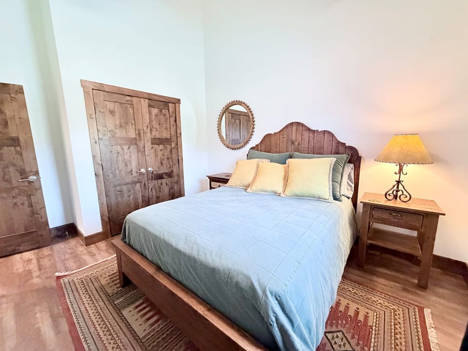 3) Cozy bedroom with queen bed, wood furnishings, and easy access to storage.
