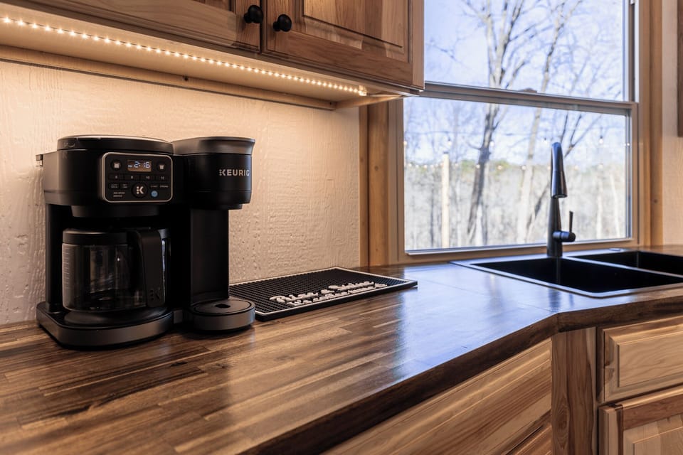 Start your morning with fresh coffee and peaceful forest views from the kitchen sink