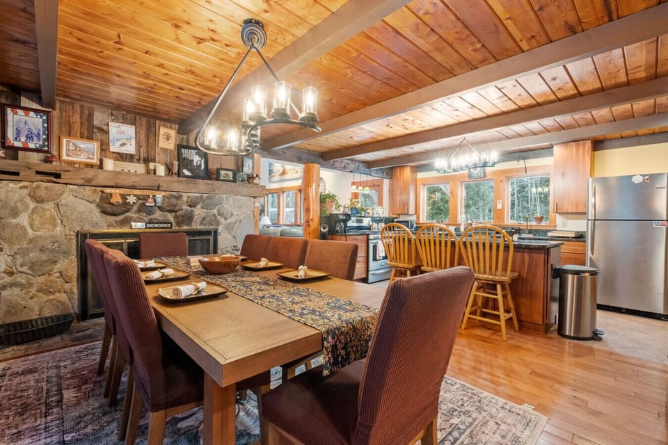 A spacious dining setup with forest views in every direction. Fireplace is not operational and only decorative