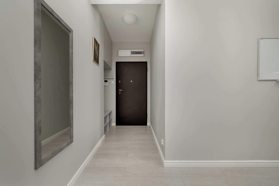 A bright hallway with a large mirror and clean design greets guests with modern elegance.