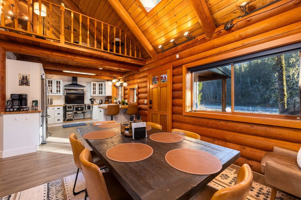 Gather around this warm, rustic dining table for meals, games, and memories. Set beneath soaring wood beams with forest views, it’s the perfect spot to connect after a day of adventure.