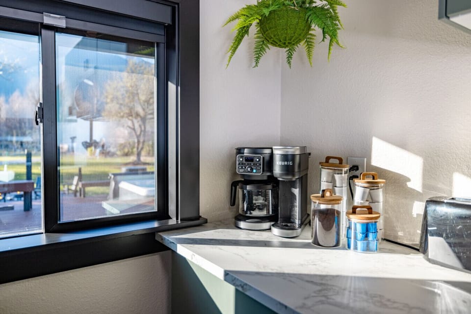 Coffee with a view! Fuel up for your daily adventures at this sun-drenched nook. We provide the essentials so you can simply grab a cup, soak in the scenery, and plan your day in peace.