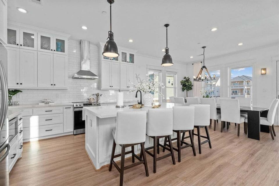 Gourmet kitchen with oversized island, bar seating, custom cabinetry, and stainless steel appliances.