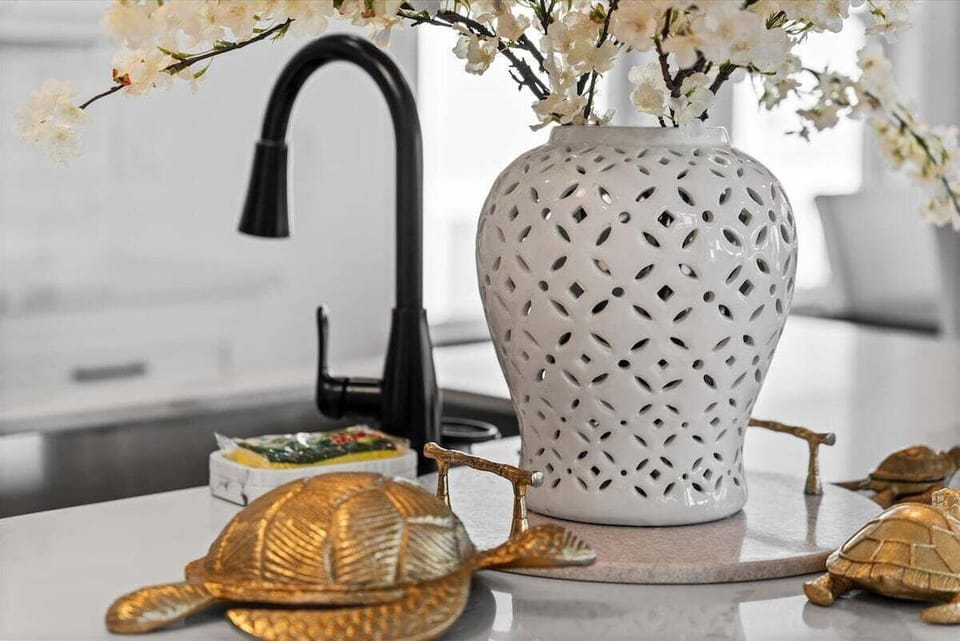 Kitchen detail showcasing designer faucet, coastal décor accents, and premium finishes.