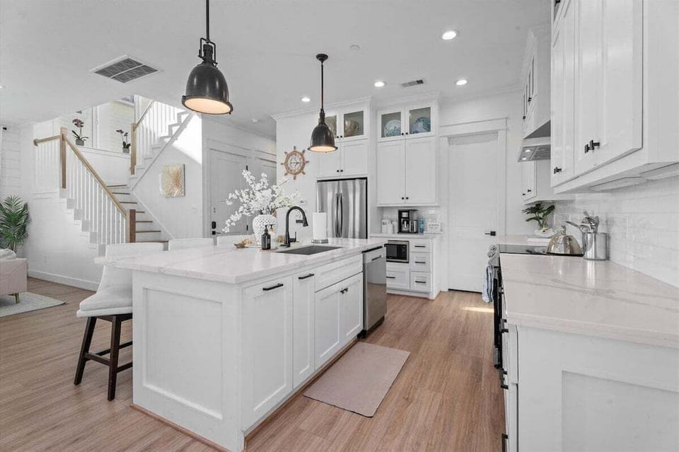 Open kitchen layout with high-end appliances and direct access to dining and living areas.