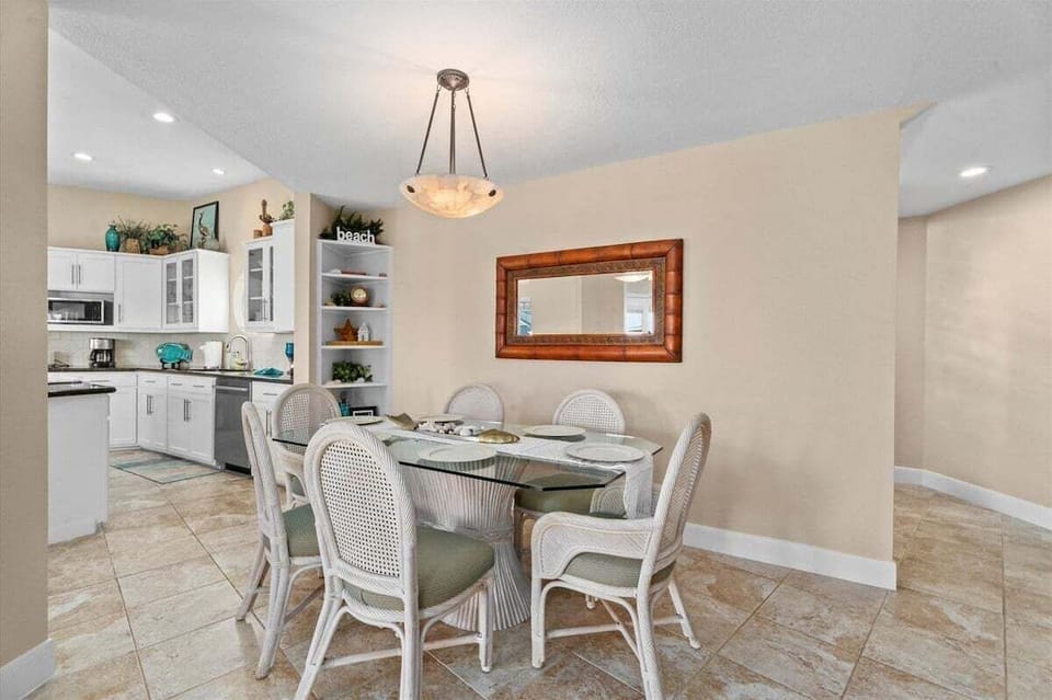 Dining area with elegant seating and open connection to kitchen, ideal for family meals near the beach.