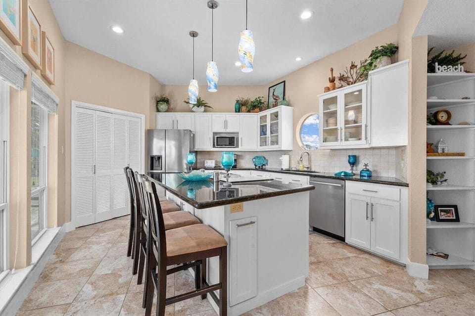 Fully equipped kitchen with stainless steel appliances, large island, and modern finishes for vacation stays.