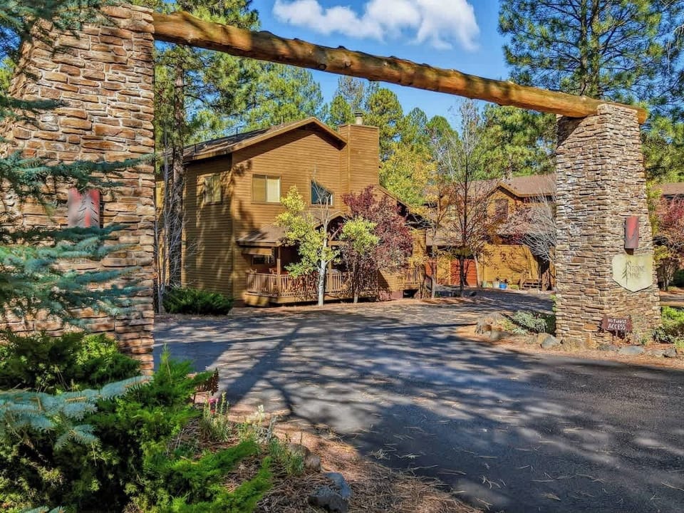 Charming cabin-style exterior surrounded by serene pine trees and mountain air.